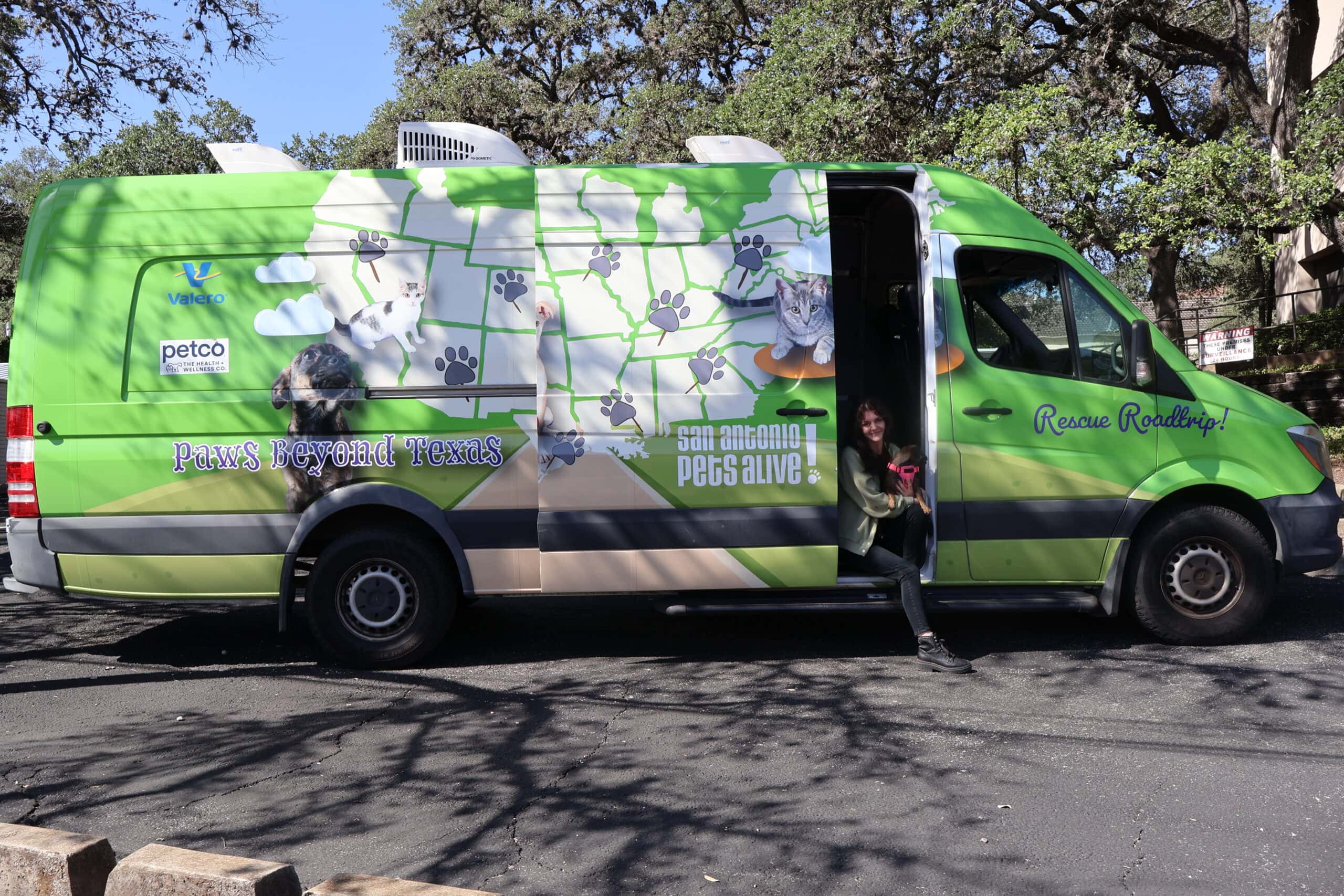 Green rescue van with animal graphics and logos.