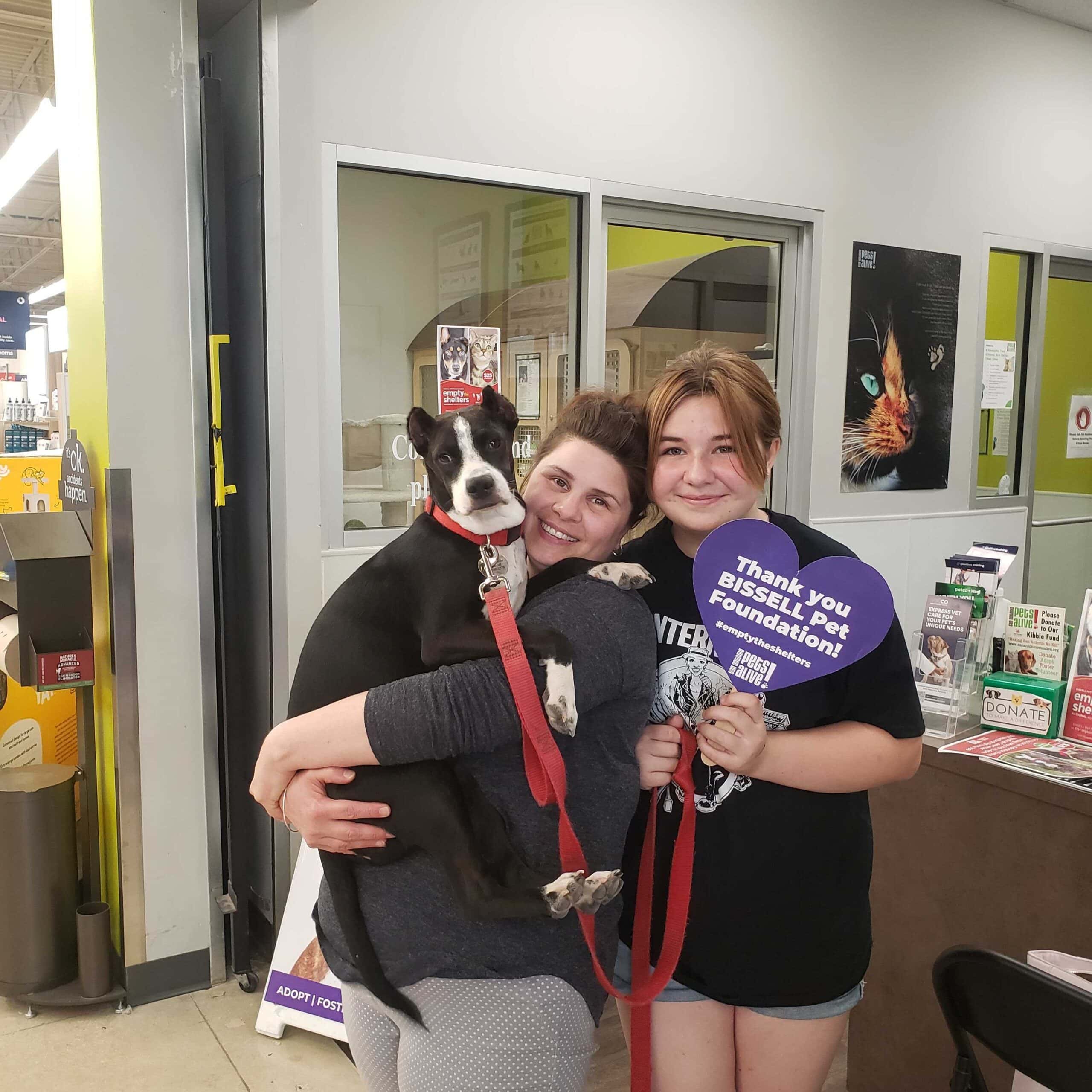 A San Antonio family smiling with their newly adopted dog, who received all initial vaccinations and preventatives from San Antonio Pets Alive!